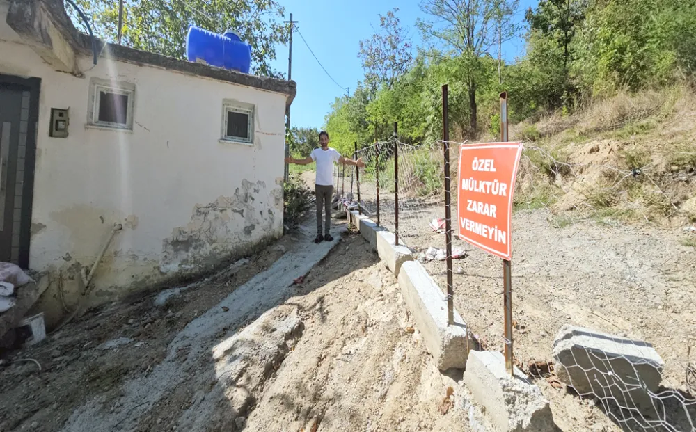 Arazisinden geçen yolu, tel örgü ve beton bloklarla kapattı
